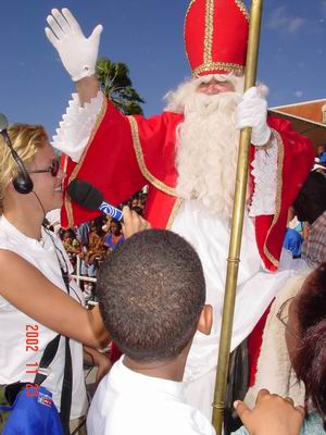 Sint wordt geinterviewd, ook zichtbaar het achterhoofd van Luchiano en een stukje van Lucy