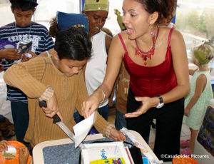 Onder toeziend oog van zijn moeder Jackeline snijdt Lennon de taart aan voor zijn tiende verjaardag. Klik voor groter!